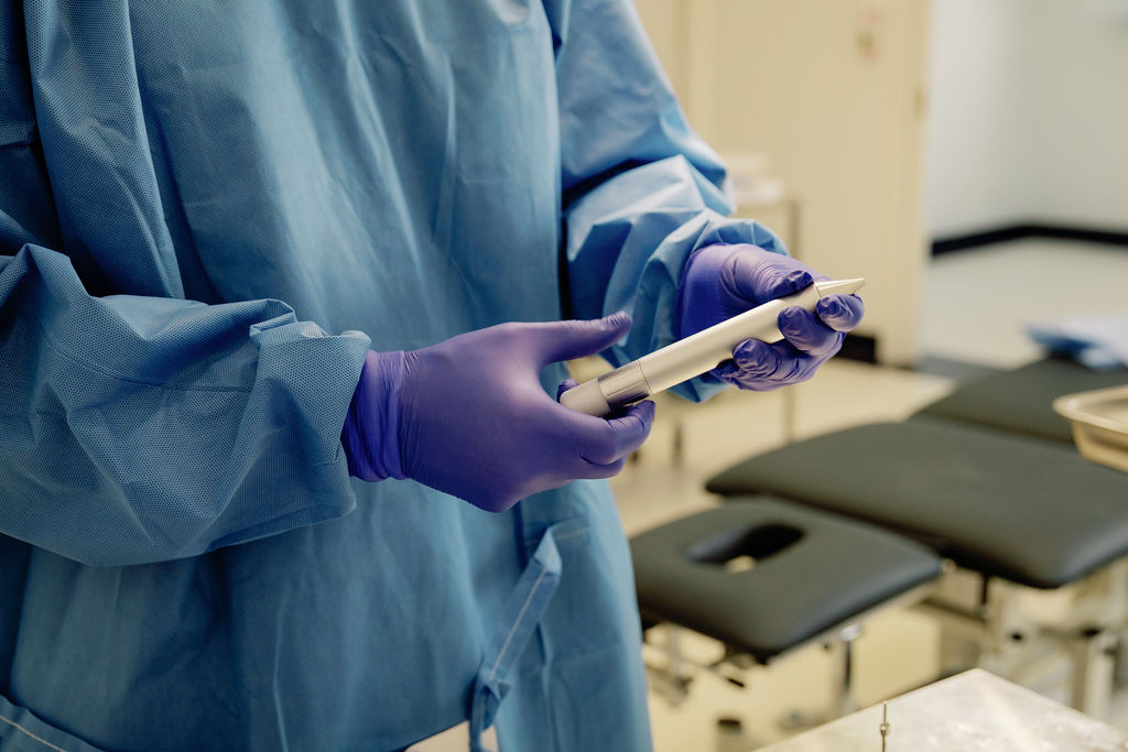 The WAW champagne-coloured wireless FUE extraction handpiece, held during a procedure at 3D Hair Transplant