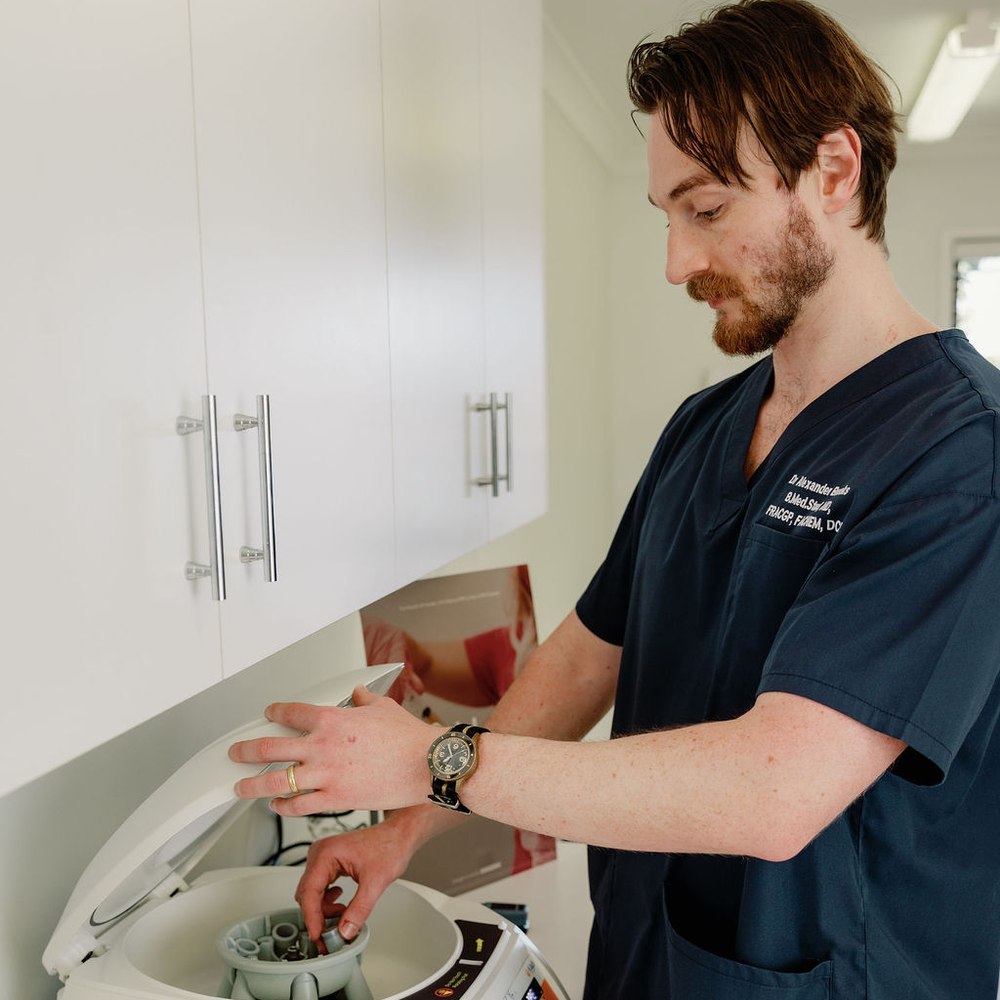 Dr Alexander Brooks preparing a treatment in the clinic’s day-surgery room at 3D Hair Transplant, Gold Coast