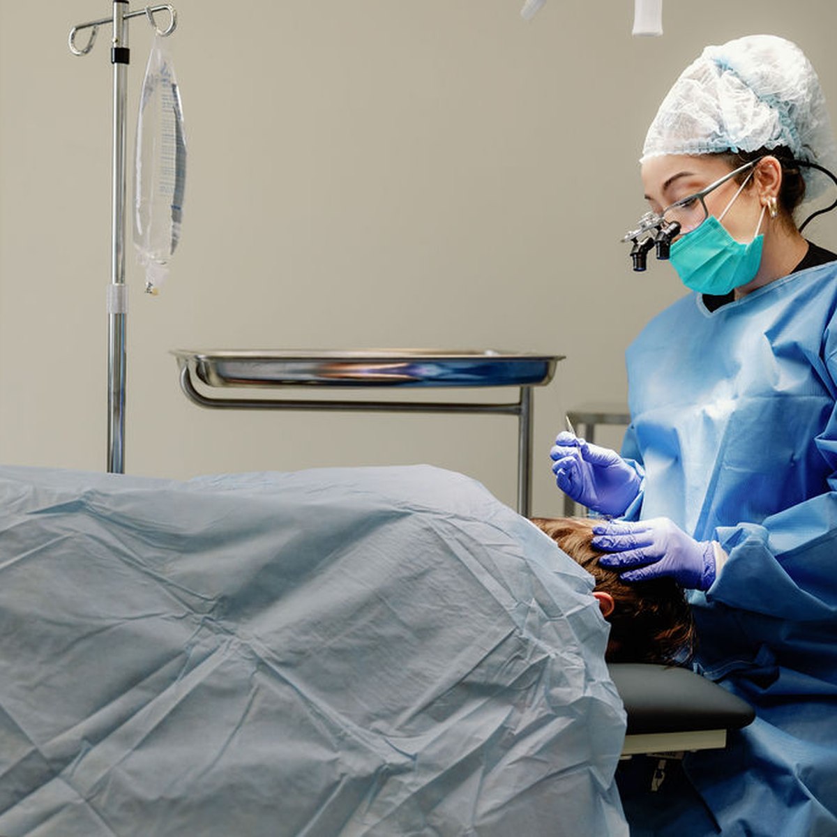 Doctors performing a follicular unit extraction (FUE) hair transplant under surgical lighting at 3D Hair Transplant, Gold Coast